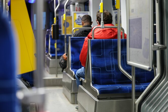 Fahrgäste sitzen in einer Straßenbahn der Leipziger Verkehrsbetriebe im morgendlichen Berufsverkehr