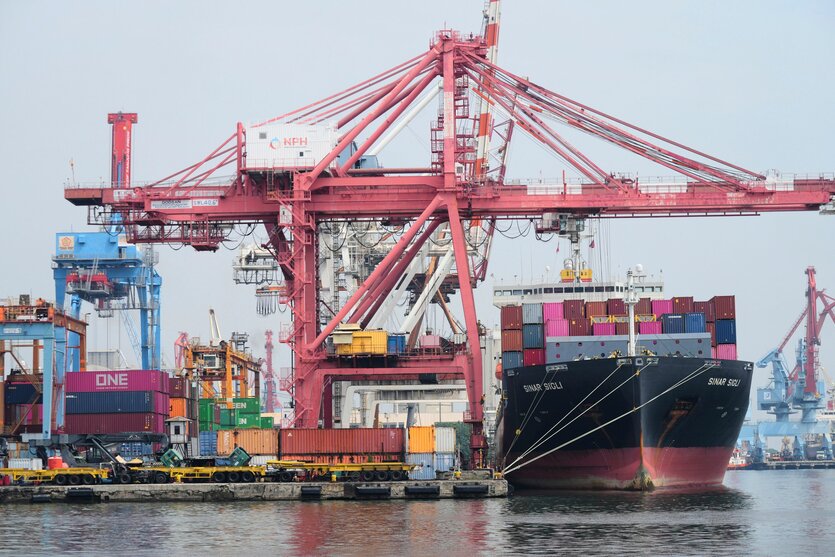 Kräne verladen Schiffscontainer auf ein Frachtschiff am Jakarta International Container Terminal im Tanjung Priok Hafen