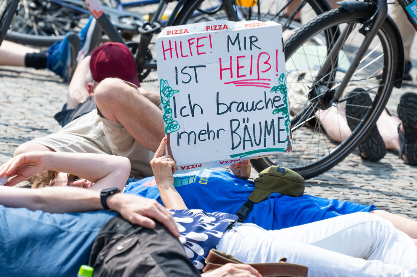 Teilnehmer liegen bei einer Demonstration des Bündnisses "BaumEntscheid" auf dem Boden auf dem Pariser Platz und simulieren einen Hitzetod.