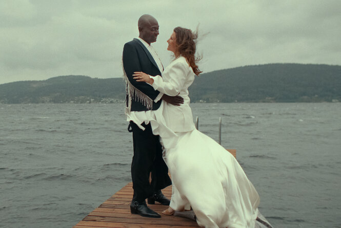 EIn Paar in Hochzeitskleidung auf einem Steg