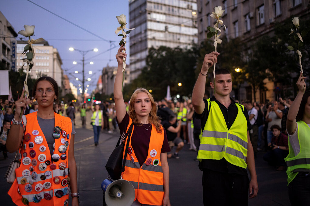 Menschen mit Blumen bei einem Protest.
