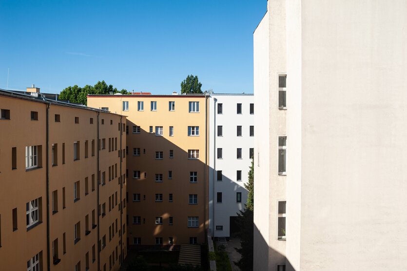 Das Foto zeigt einen Blick in den Hinterhof von sechsgeschossigen Mietwohnungshäusern in Berlin.