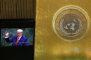 Auf einem Bildschirm ist US-Präsident Donald Trump zu sehen, wie er vor der 80. Generalversammlung der Vereinten Nationen im UN-Hauptquartier spricht, direkt neben dem großen, raumnehmenden UN Logo