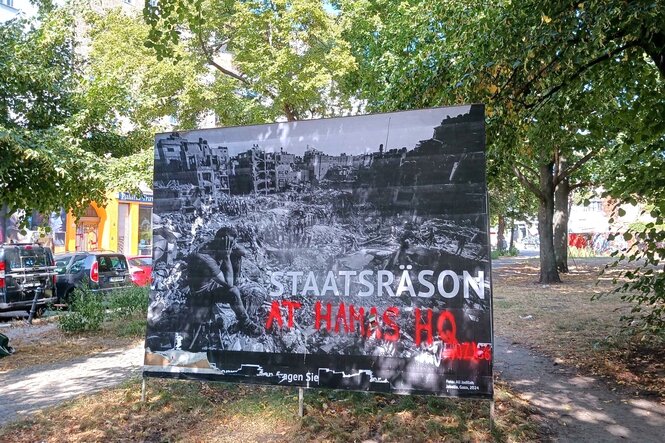Plakat zeigt Zerstörung in Gaza mit Titel: Staatsräson - darauf mit roten Buchstaben: At Hamas HQ