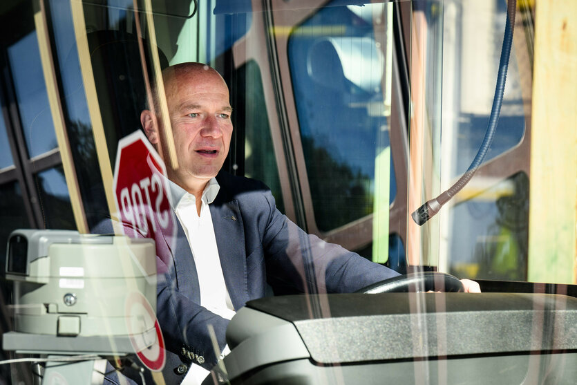Kai Wegner sitzt mit offenem Mund vor dem Steuer eines Busses.