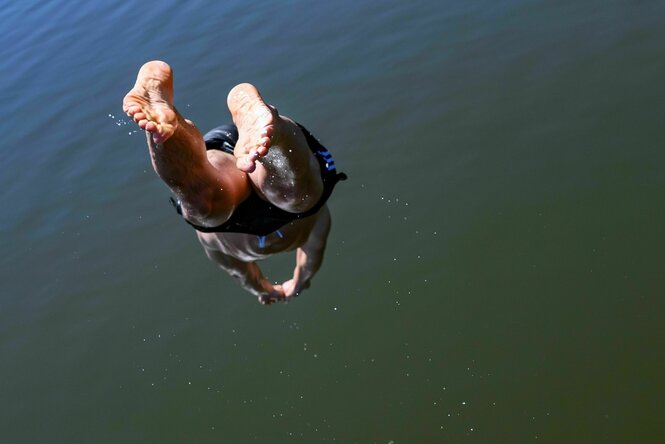 Ein Mann springt kopfüber in einen See