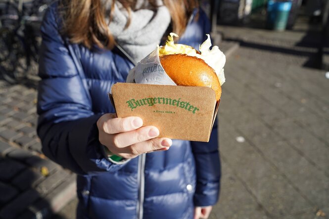 Eine Frau hält einen Hamburger in der Hand