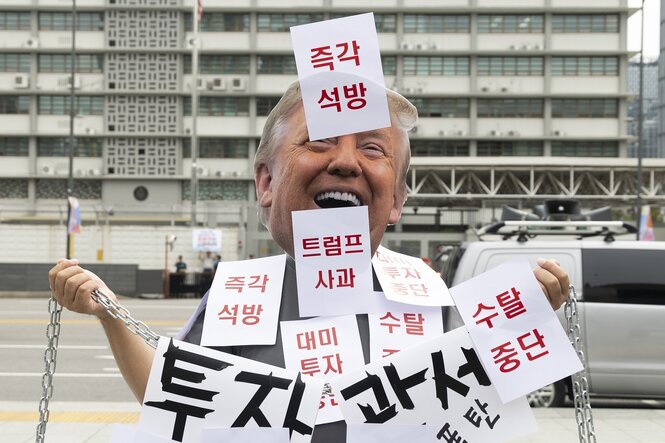 Jemand trägt eine Maske mit dem gesicht Donald TRumps und viele Zettel mit Koreanischen Buchstaben