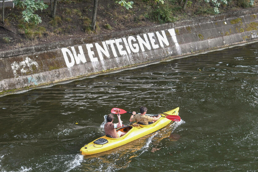 Blik auf einen Kanal, an dessen mauer DW enteignen steht.