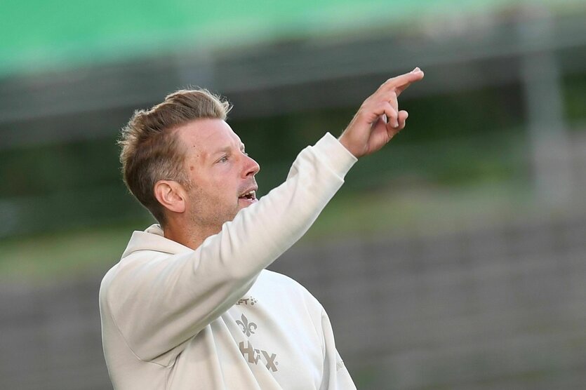 Trainer Föorioan Kohledt zeigt mit dem Finger aufs Feld