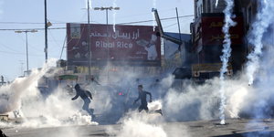 Die Aufstände werden durch Tränengas aufgelöst, Menschen rennen über die Straße