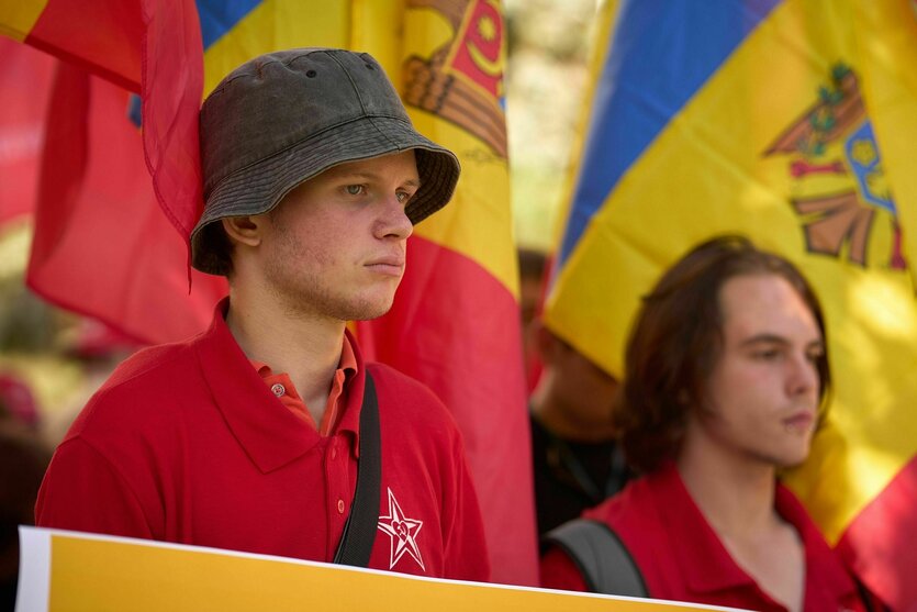 zwei junge Männer vor gelb-roten Fahnen