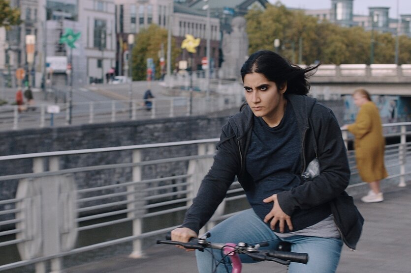Ein Bild aus einem Film, eine Frau fährt auf dem Rad: Eine Szene aus dem Auftaktfilm „The Virgin and Child“