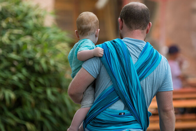 Ein Mann hält ein Baby auf dem Arm. Die Rolle des Mannes in der Gesellschaft hat sich - zum Teil - verändert