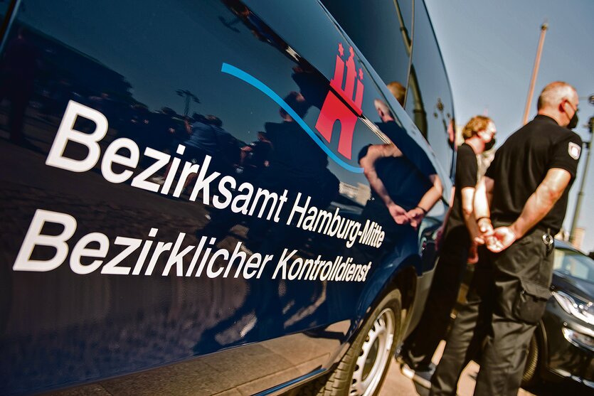 Männer in schwarzen Hemden stehe neben einem Auto