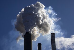 Schornsteine eines Kohlekraftwerks stossen Rauch aus