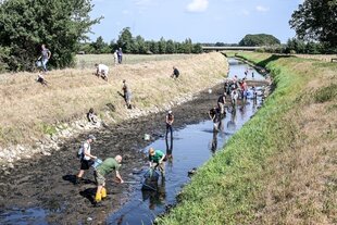 Menschen waten in einem Flüsschen