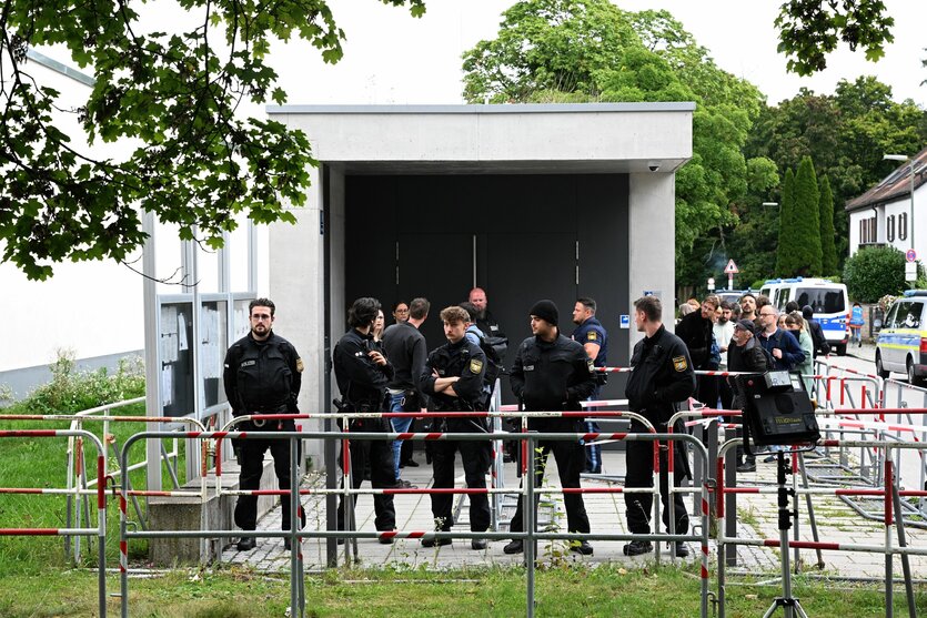 Polizisten stehen hinter Absperrgittern