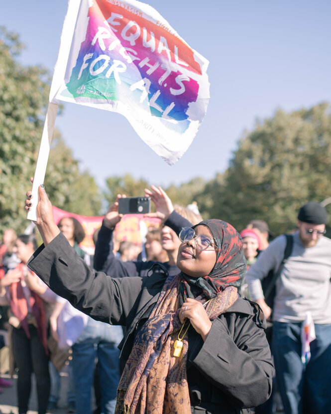 Frau mit Flagge mit der Aufschrift "gleiches Recht für alle"