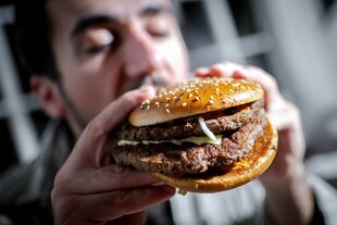 Mann beißt in einen Burger