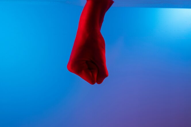 eine geballte Faust in rot vor blauem Hintergrund