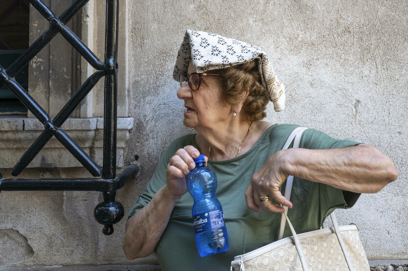 Eine Frau schützt sich mit einem Tuch auf dem Kopf vor der Hitze