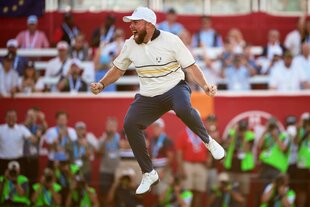 Shane Lowry springt jubelnd in die Luft, im Hintergrund die Tribüne