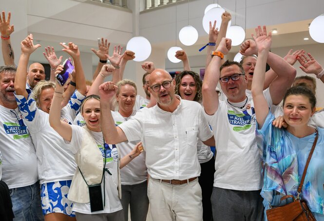 Eine Gruppe Menschen, manche mit weißen T-Shirt auf denen 