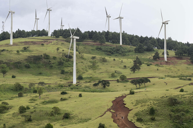 Windräder stehen in einer hügeligen Landschaft