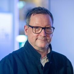 Zu sehen ist der Schauspieler Matthias Brandt in einem blauen Pullover.