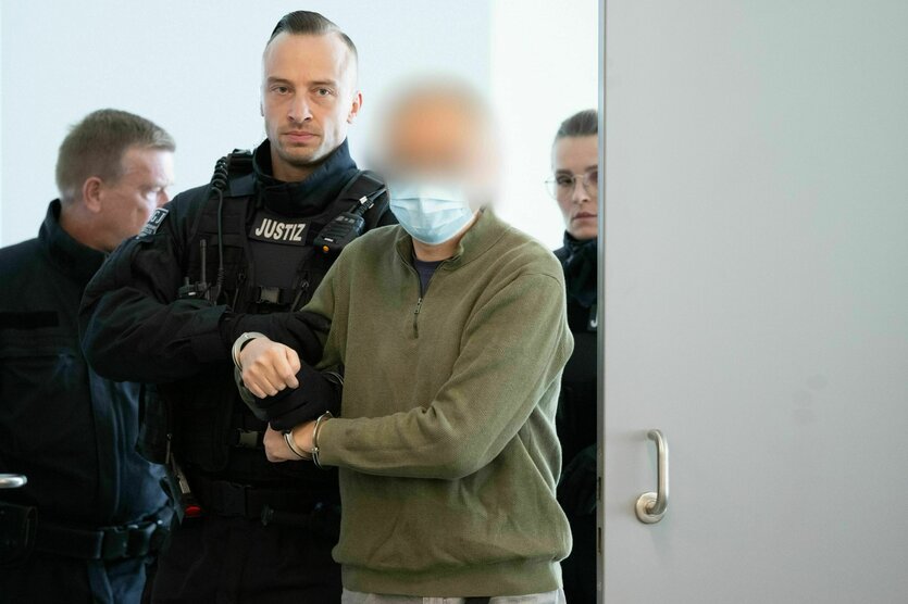 Der Hauptangeklagte Jian G. (r) wird vor Prozessbeginn in den Gerichtssaal geführt