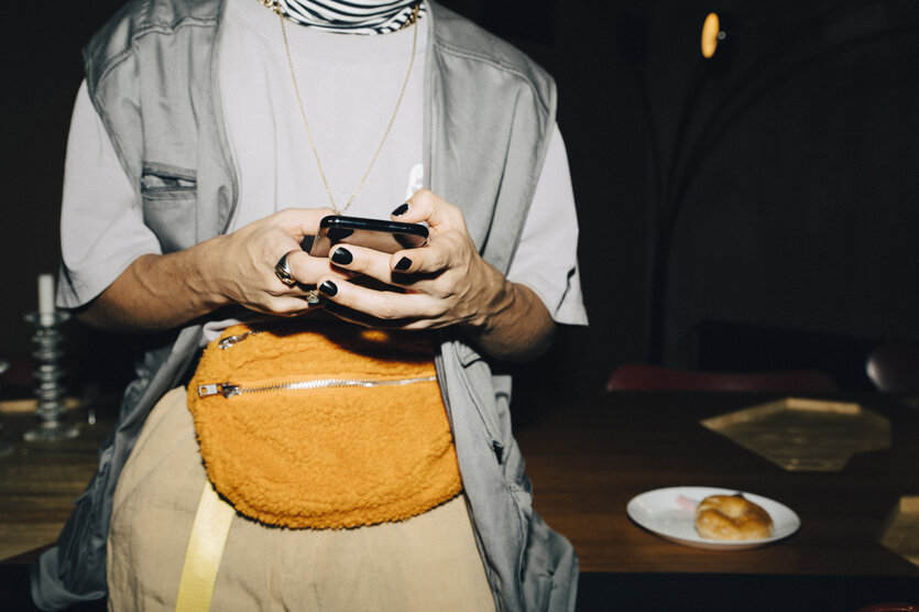 Ein Mann mit schwarzem Nagellack tippt in sein Handy
