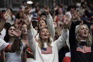 Viele menschen heben ihre Arme in die Höhe und singen