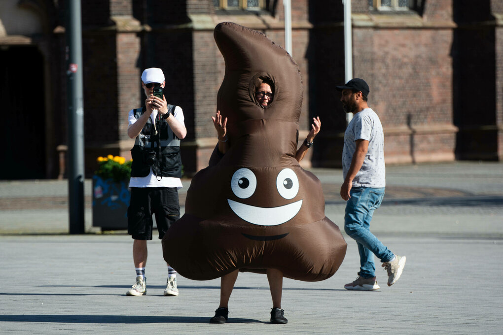 Ein Demonstrant auf der Straße mit einem Kostüm in Form eines Kackhaufens