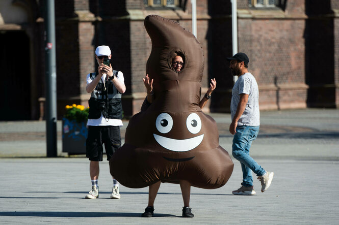 Ein Demonstrant auf der Straße mit einem Kostüm in Form eines Kackhaufens