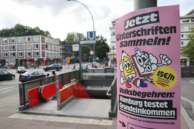 Ein Plakat zum Volksbegehren für ein Grundeinkommen ist in Hamburg-Eimsbüttel zu sehen.