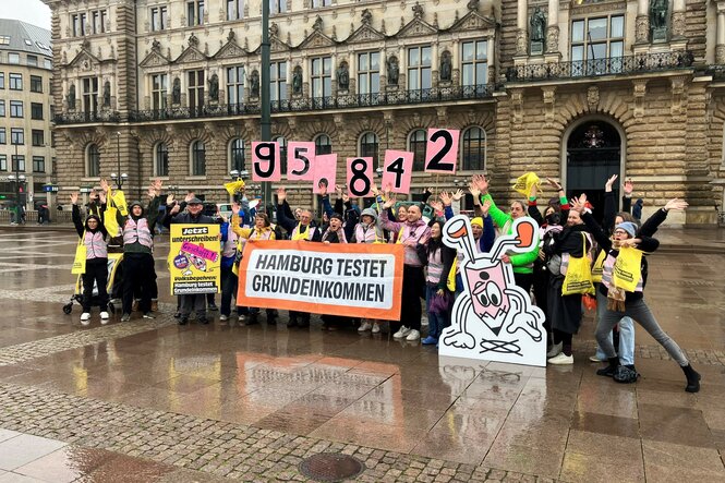 Vertreter der Volksinitiative "Hamburg testet Grundeinkommen" jubeln auf dem Hamburger Rathausmarkt über 95.842 gesammelte Unterschriften