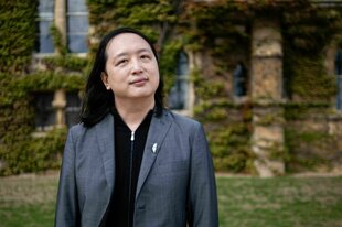 Audrey Tang schaut in die Kamera. Im Hintergrund sieht man eine efeubewachsene Mauer