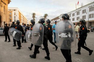 Polizisten mit Helmen und Schutzschioldern