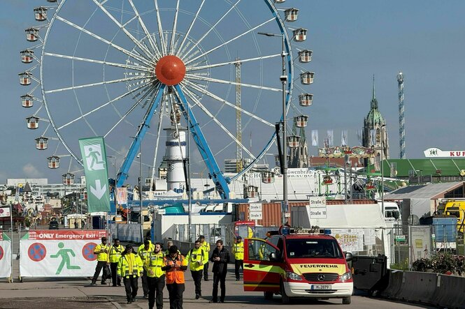 Sicherheitsbeamte auf dem Oktoberfest, im Hintergrund ist ein Riesenrad zu sehen