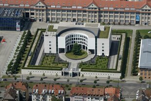 Ein großes Gebäude mit Parkanlage aus der Vogelperspektive