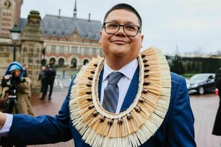 Der Klimaschützer Julian Aguon steht mit einem Halsschmuck aus Polynesien auf einem Platz, es ist regnerisch
