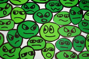 in sattem grüne gemalte Smileys und weniger oder mehr glückliche Gesichter