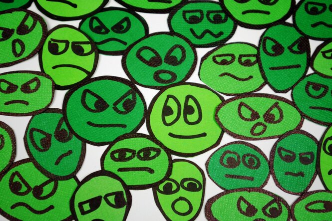in sattem grüne gemalte Smileys und weniger oder mehr glückliche Gesichter
