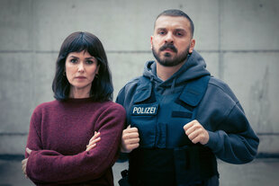 eine Frau in zivil und ein Mann in Polizeiuniform