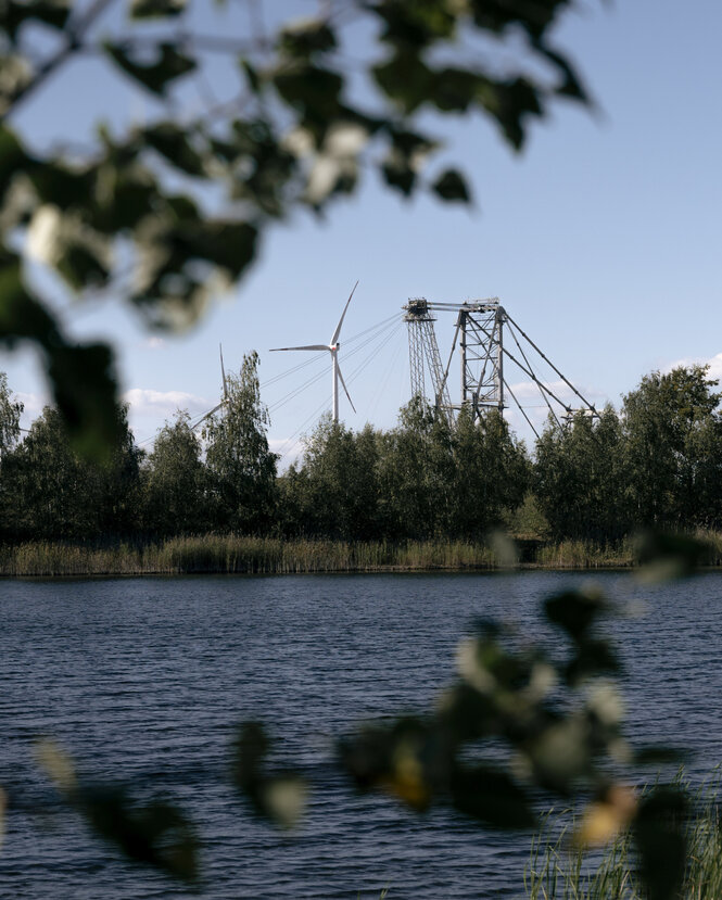 Ein See, im Hintergrund ein Bagger in einem Tagebau.