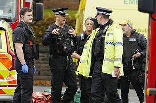 Einsatzkräfte der Polizei am Tatort, ein Helfer trägt eine neongelbe Weste