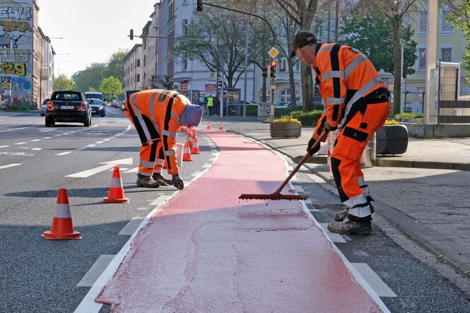 Zwei Männer bauen eine Fahrradstraße