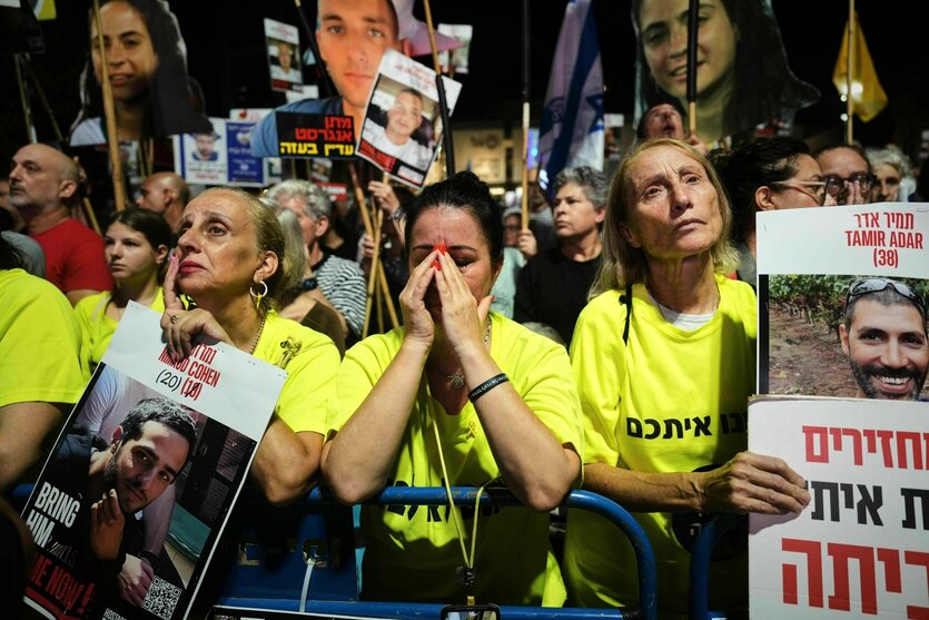 Angehörige und Unterstützer*innen fordern bei einem Protest für die Freilassung der Geiseln und eines Ende des Krieges. Sie haben Schilder mit den Fotos der verschleppten Geiseln bei sich