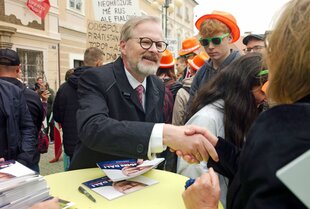 Ein Mann, umringt von anderen Perseonen, schüttelt Hände